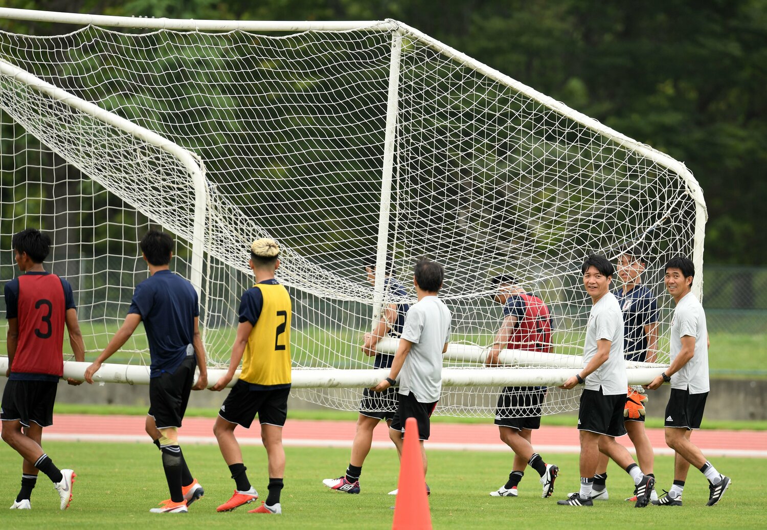 練習を終え、選手たちと一緒にゴールを運ぶ森保一監督（右）。写真は2018年8月　©Nikkan Sports