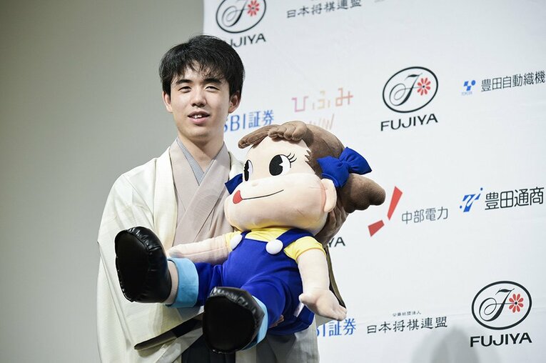 ペコちゃんを優しく抱える藤井 ／ photograph by Wataru Sato