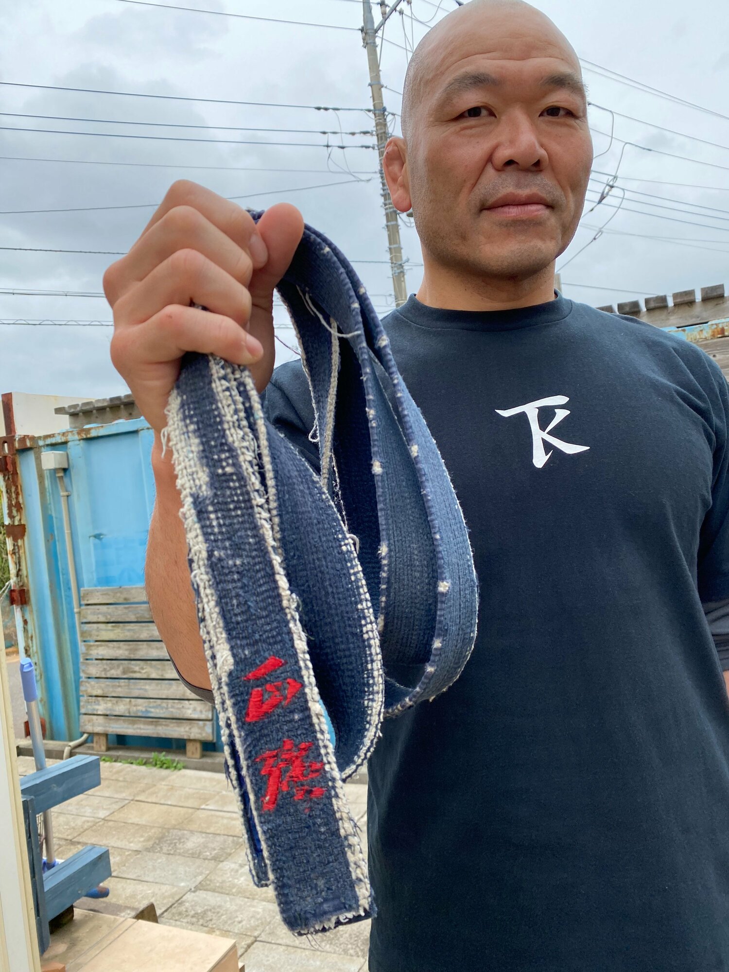 試合翌日、茨城の自宅で独占インタビューに応じた高阪。持っているのは中学時代に初めて締めた柔道の黒帯。これを握りしめて最後のリングへと向かっていった　©Gantz Horie