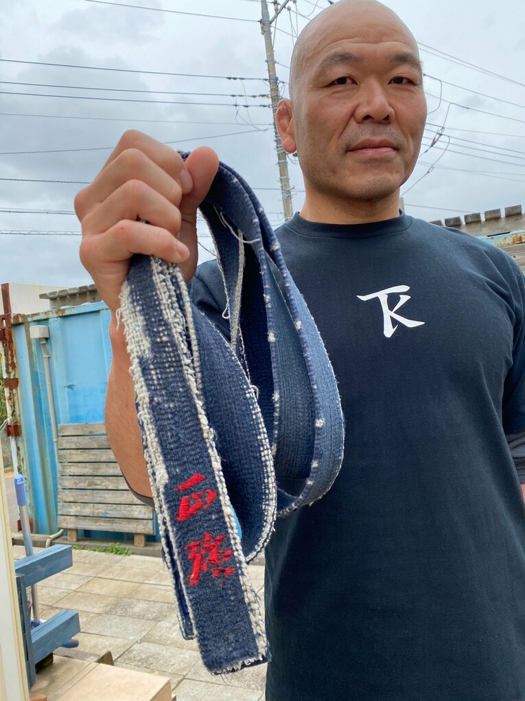 試合翌日、茨城の自宅で独占インタビューに応じた高阪。持っているのは中学時代に初めて締めた柔道の黒帯。これを握りしめて最後のリングへと向かっていった　©Gantz Horie