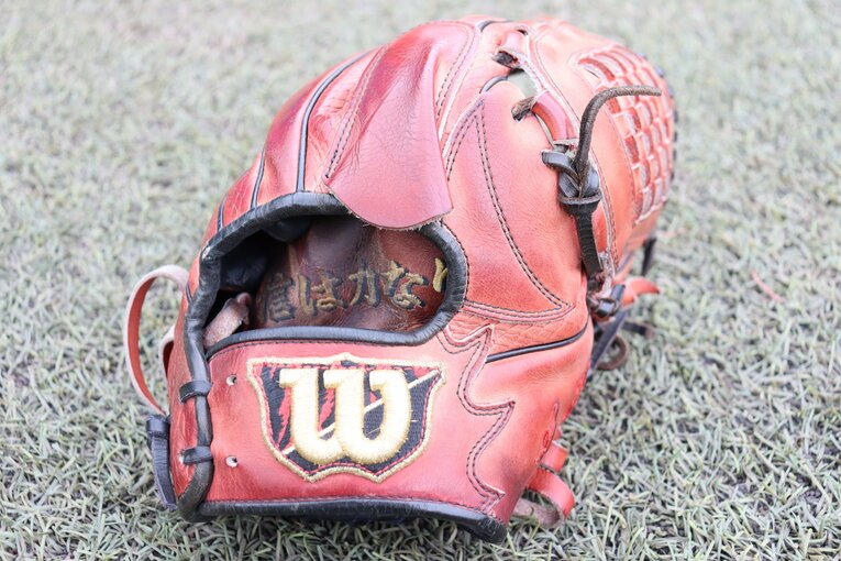 「信は力なり」が刺繍された荘司のグローブ ©Genki Taguchi