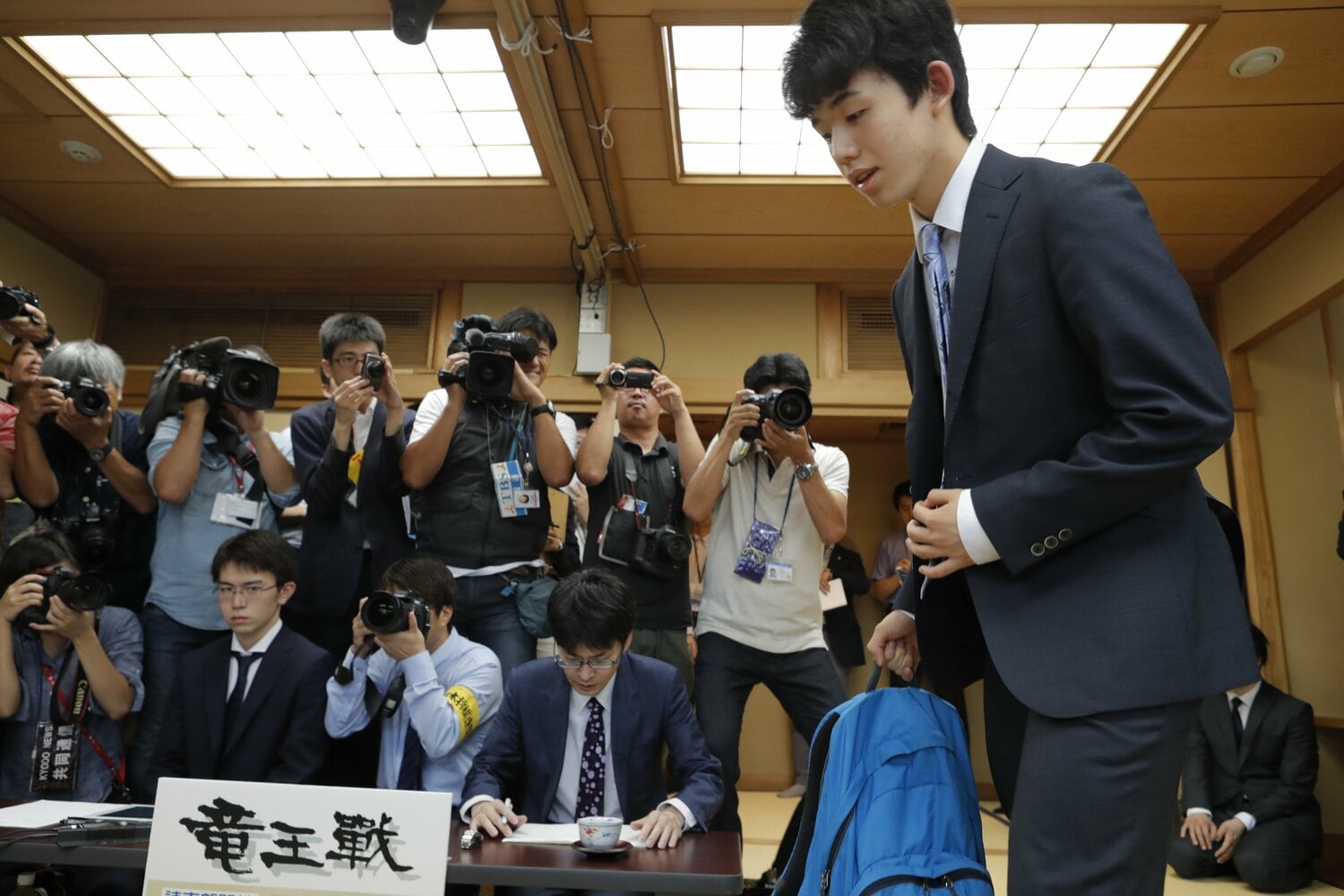 スカイブルーのデイパックを持って入室する藤井　©Tadashi Shirasawa