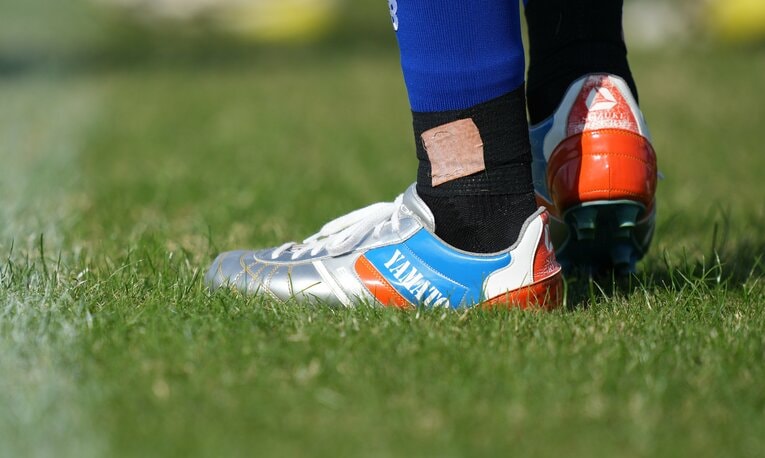 「試合用のスパイク、履くと感謝の気持ちでいっぱいになる」。大学時代から愛用するスズキスポーツが激励を込めて特注カラーのスパイクを贈ってくれたという　©Akito Iwamoto