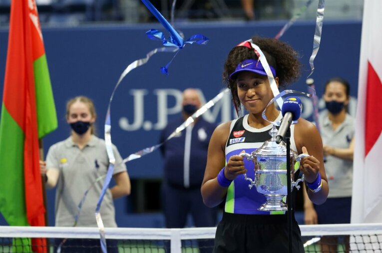 日の丸をバックに優勝トロフィーを掲げた。 ／ photograph by Getty Images