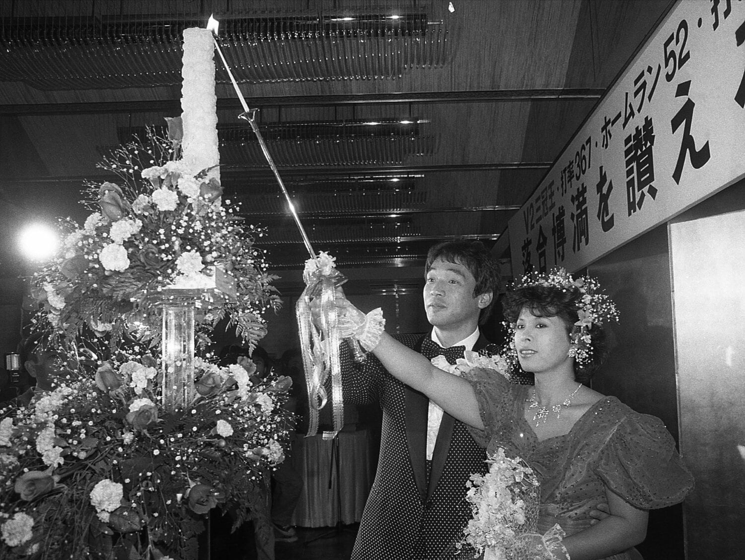 写真は1985年12月、落合の祝賀パーティー「V2三冠王 落合博満を讃える会」。前年12月に入籍した信子夫人と1年遅れの披露宴を行った。キャンドルに火をともすタキシード姿の落合と信子夫人。港区白金台の八芳園で　©Sankei Shimbun