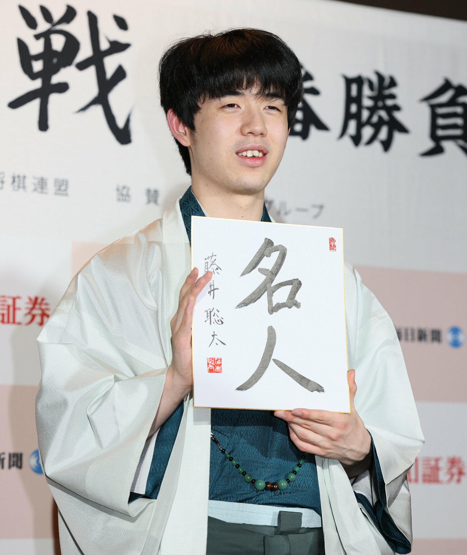 会見で「名人」の色紙を手にした藤井七冠　©JIJI PRESS