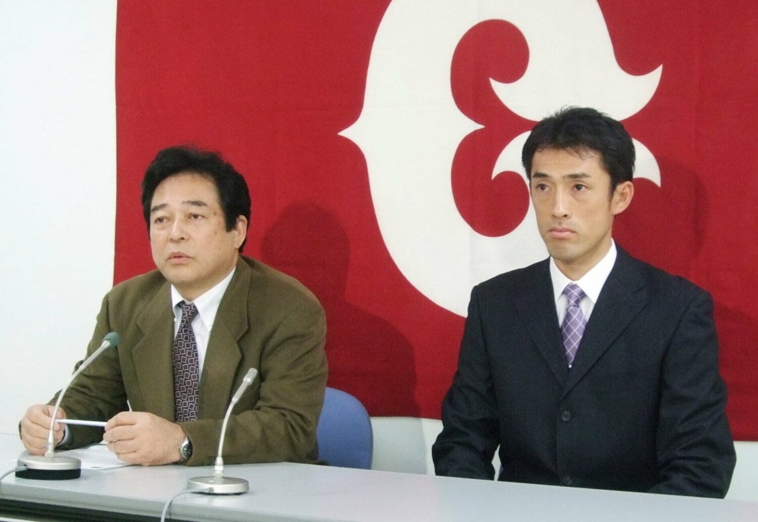 オリックスへのトレード移籍が決まり、巨人・清武英利球団代表と並んで記者会見する木佐貫　©KYODO