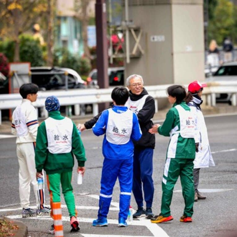 他の給水員の学生たちと一緒に笑顔でランナーを待つ八田教授／本人提供