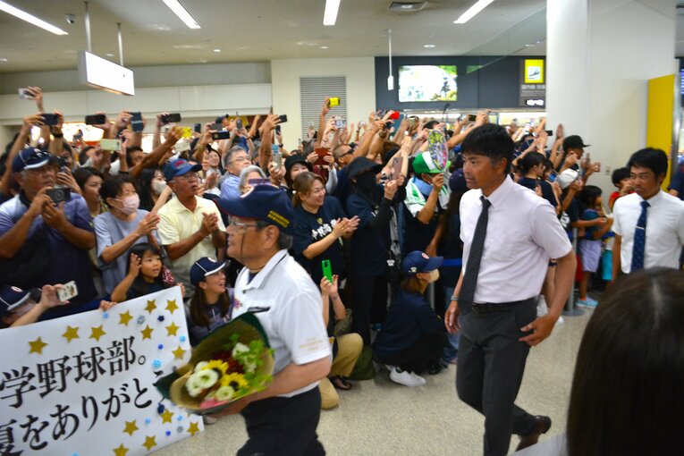 熱烈な出迎えを受けても表情を崩さない比嘉公也監督　©Takarin Matsunaga