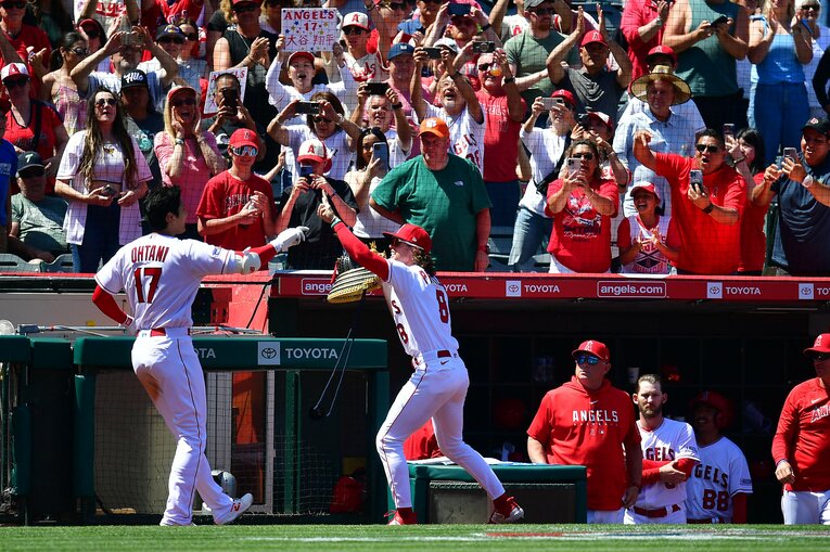 “初代兜担当”フィリップスから兜をかぶせてもらおうとする大谷　©AFLO