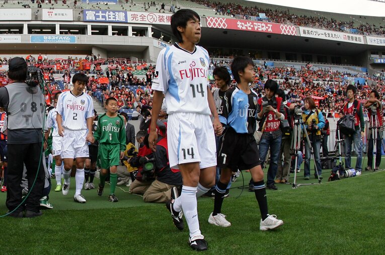 小学生の頃の三笘薫と手をつないで選手入場する中村憲剛　©J.LEAGUE