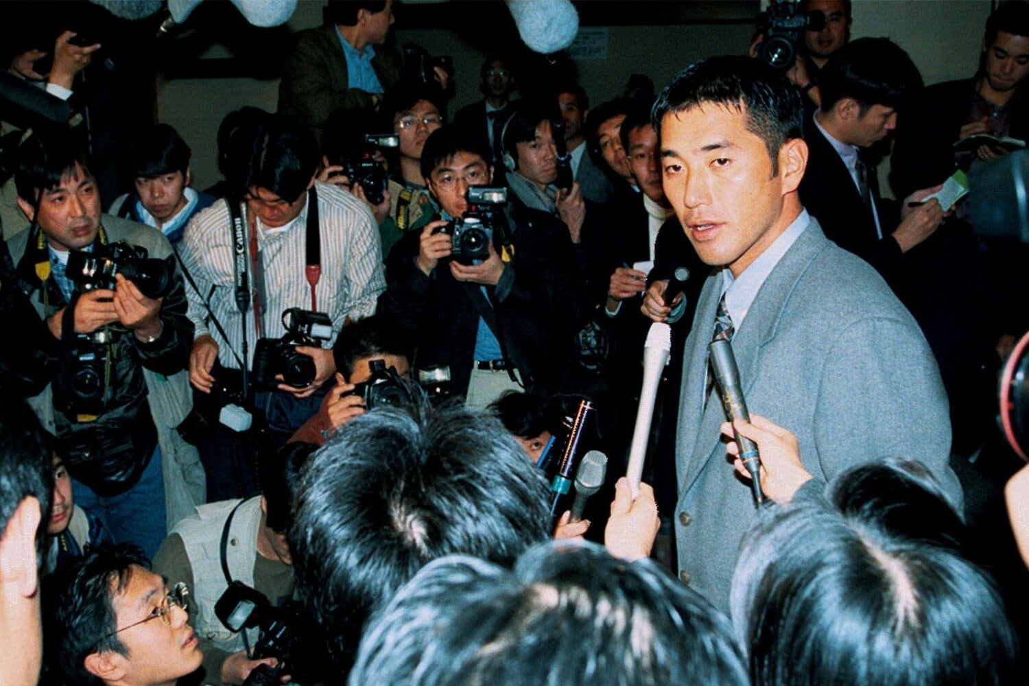1996年11月13日、巨人との初交渉を終え、大勢の報道陣に囲まれる清原。その表情は硬かった　©KYODO