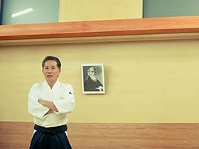 合気道の開祖、植芝盛平（1883-1969）の肖像の前で
                                                       