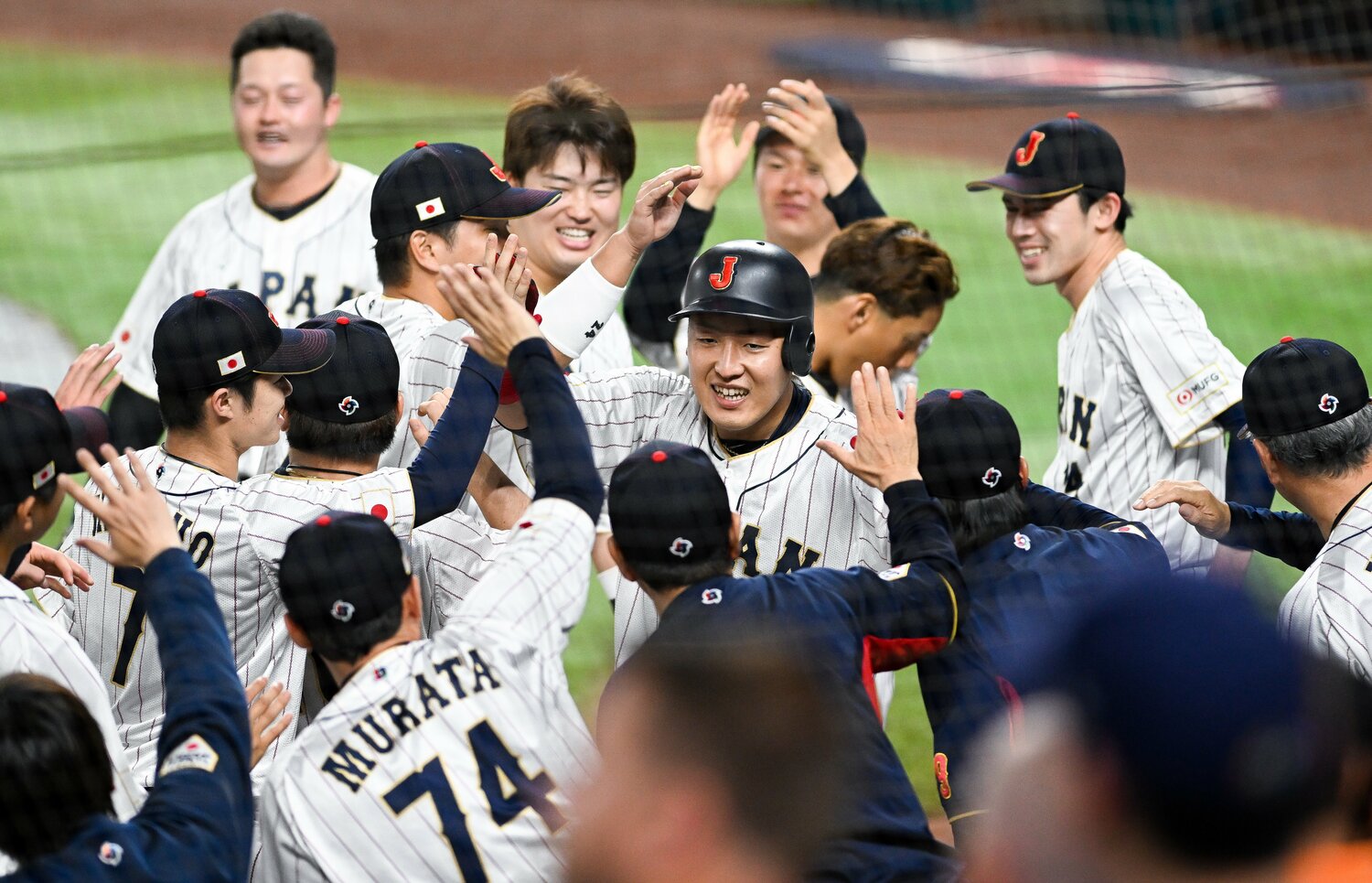 アメリカとの決勝戦、4回にチーム3点目となる2号ソロホームラン。ナインとハイタッチし喜びを露わにした岡本和真（26歳）　©Getty Images