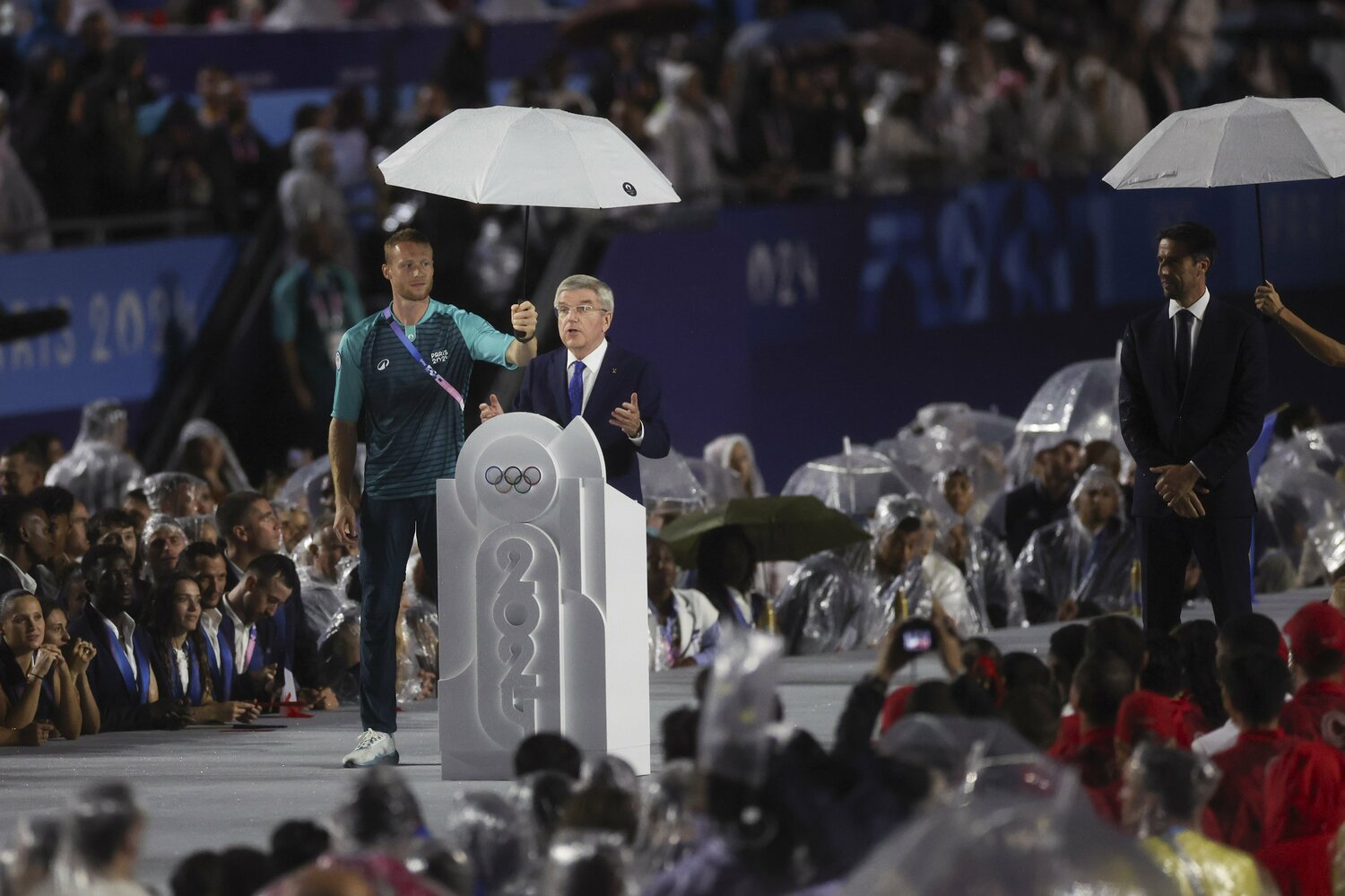 観衆が雨に濡れる中、「傘持ち」つきでスピーチするIOCのトーマス・バッハ会長　©JMPA PK AFLO