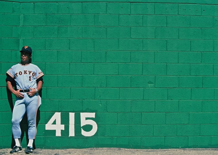 グアムキャンプ・パセオ球場の塀にもたれる王監督（1984年）©︎Kazuhito Yamada