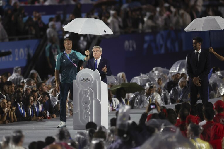 観衆が雨に濡れる中、「傘持ち」つきでスピーチするIOCのトーマス・バッハ会長　©JMPA PK AFLO
