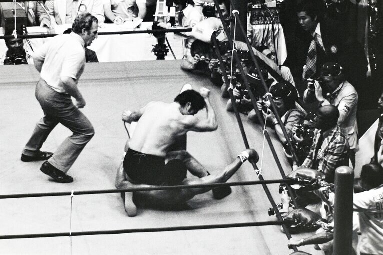 アリの上に跨り、エルボーを打ち下ろす猪木