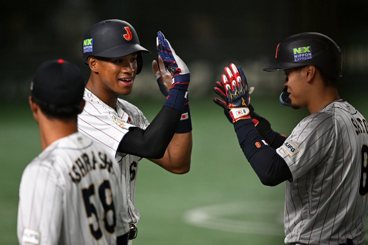 タッチアップで同点のホームを踏んだ万波中正（左）と犠牲フライを放った佐藤輝明（右）ハイタッチ　©︎Getty Images