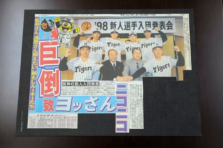1998年新入団会見の様子を報じた新聞の切り抜き。後列左から奥村武博、山岡洋之、坪井智哉、橋本大祐、前列左から井川慶、三好一彦球団社長、吉田義男監督、中谷仁（本人提供）