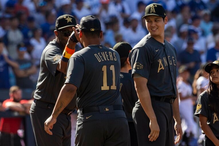 デバースとハイ・ファイブする人物がベイカー監督（妻が大谷の熱狂的ファン）。隣にはヤキモチを焼かせる大谷　©Getty Images