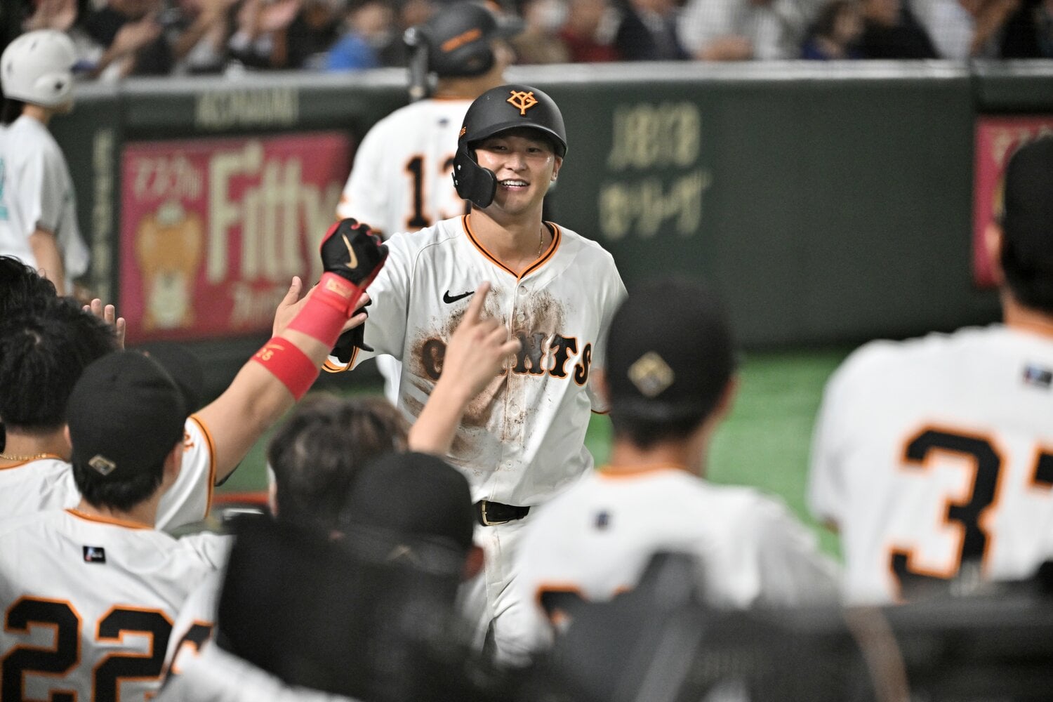 先制のホームを踏んで、巨人ベンチに迎え入れられる吉川　©︎Hideki Sugiyama