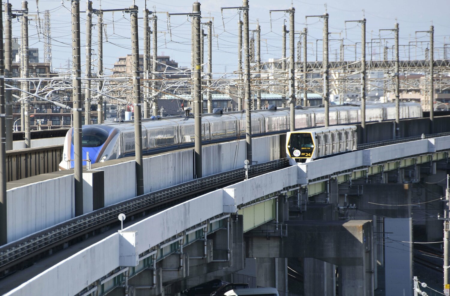 新幹線と並んで走る「ニューシャトル」（右）。コンクリートの軌道の上をゴムタイヤで走る。このニューシャトルに乗って「原市駅」を目指す　©KYODO