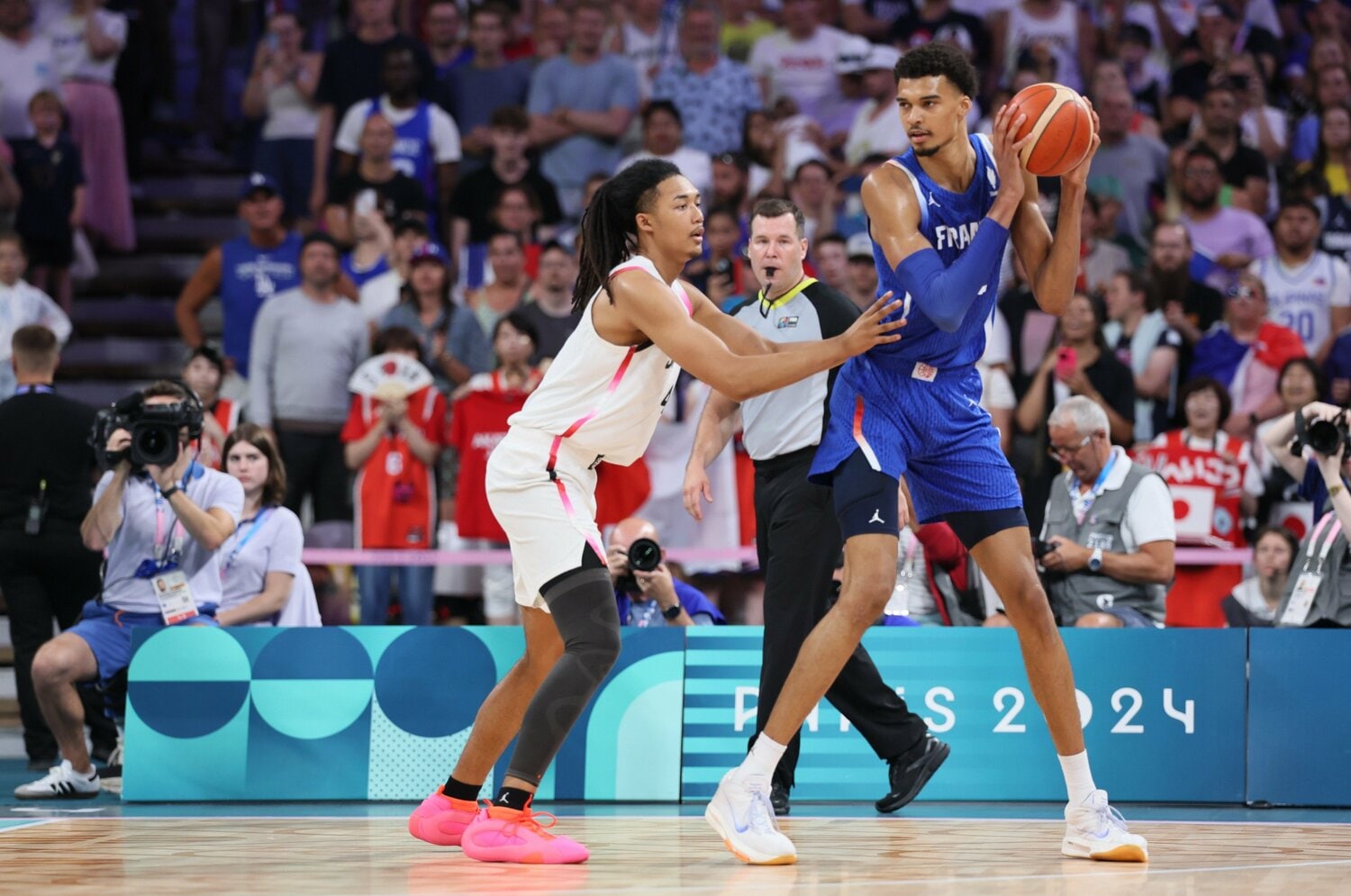 同じ2004年生まれで、NBAのスパーズでプレーするビクター・ウェンバンヤマとのマッチアップ。206cmのジェイコブスですら小粒に見えてしまう　©︎Getty Images