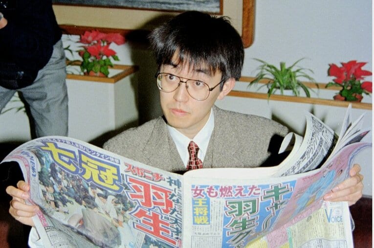 1996年2月15日、史上初の七冠独占を報じる新聞を読む羽生善治（当時25歳） ／ photograph by KYODO
