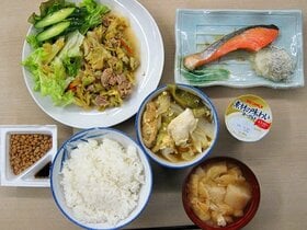 ＜晩＞　豚肉とキャベツの味噌炒め、塩鮭、白菜と油揚げの煮物、ごはん、味噌汁、納豆、ヨーグルト。「栄養士のアドバイスを受けたこともあったけど、残されちゃしょうがない。栄養素も大事だけど、おいしく食べてもらえることを一番に考えてるよ。たくさん食べてくれて嬉しいね」と寮長の金刺さん