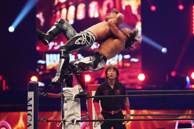 コーナーからドラゴンスープレックスを放つケニー・オメガ