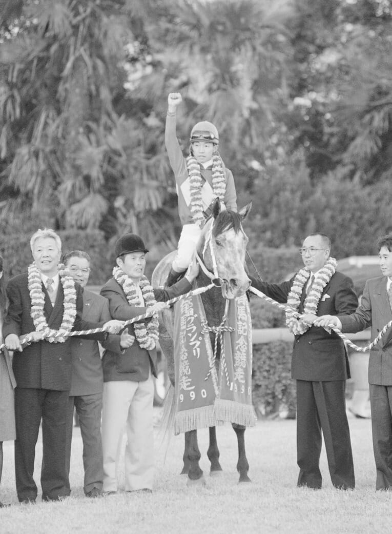 有馬記念の口取り式でのオグリキャップ。右手を掲げる当時21歳の武豊　©JIJI PRESS