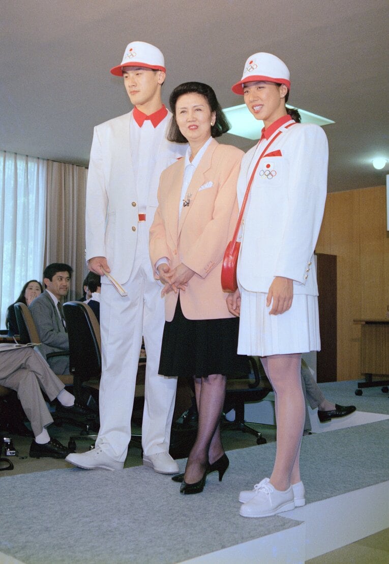 バルセロナ五輪日本選手団の公式ユニホームを披露するデザイナーの森英恵さん（中央）。モデルはバレーボールの中垣内祐一選手（左）とシンクロナイズドスイミングの小谷実可子選手　©︎JIJI PRESS　