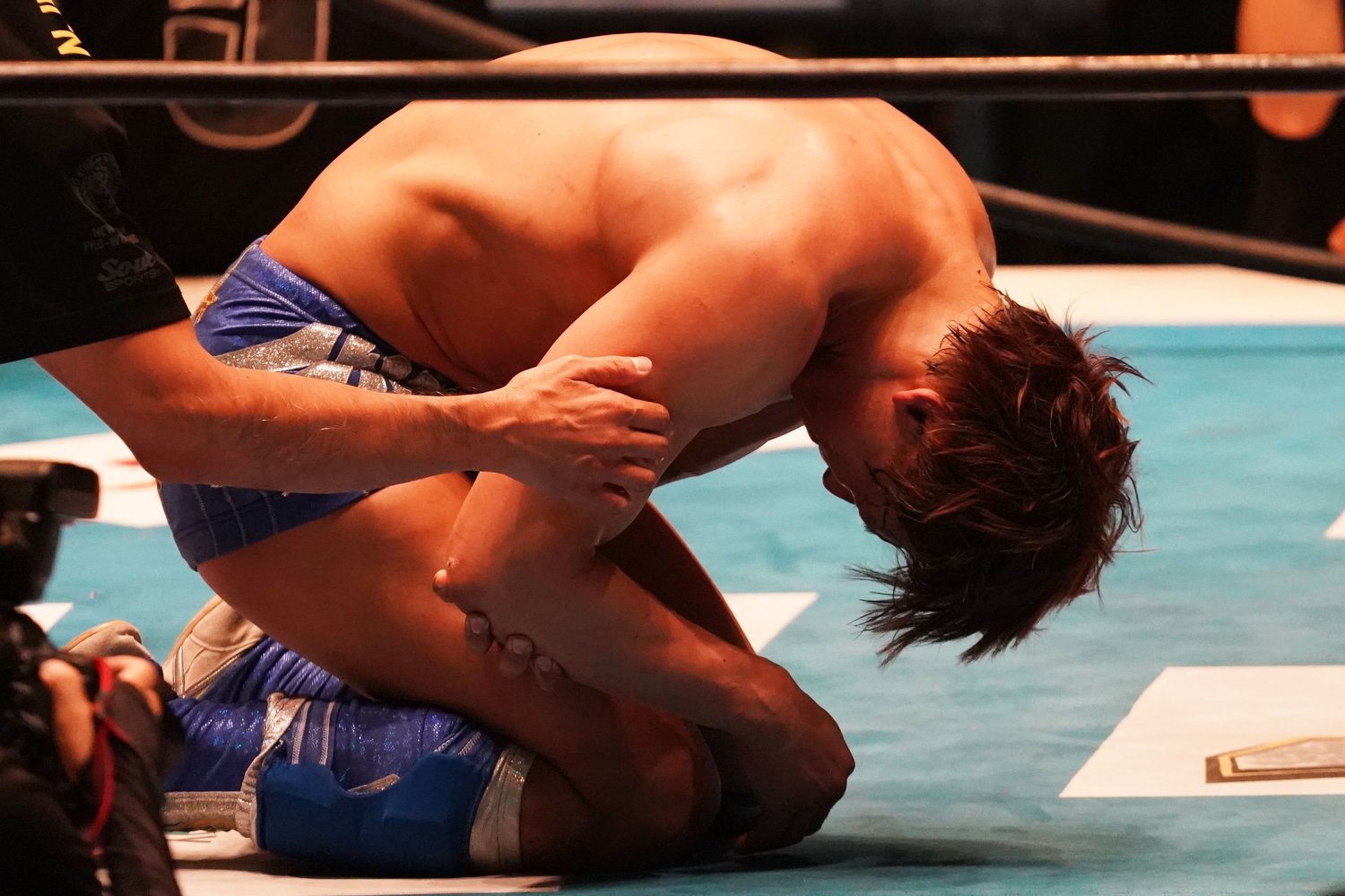 右腕を押さえてうずくまる飯伏。今年7月の誤嚥性肺炎につづくアクシデントとなってしまった