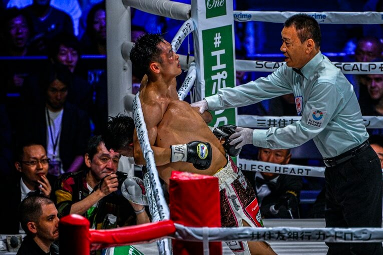 クリンチに逃れる西田凌佑。右目は痛々しく腫れ上がっていた　©Takuya Sugiyama