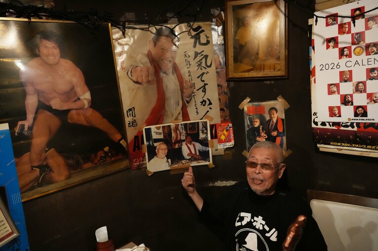 店の壁に貼られた写真の説明をする村田善則マスター　©Essei Hara