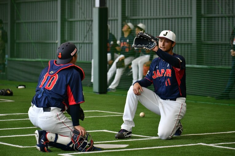 動きを交えながら甲斐に捕球について考えを伝えるダルビッシュ　©︎Hideki Sugiyama