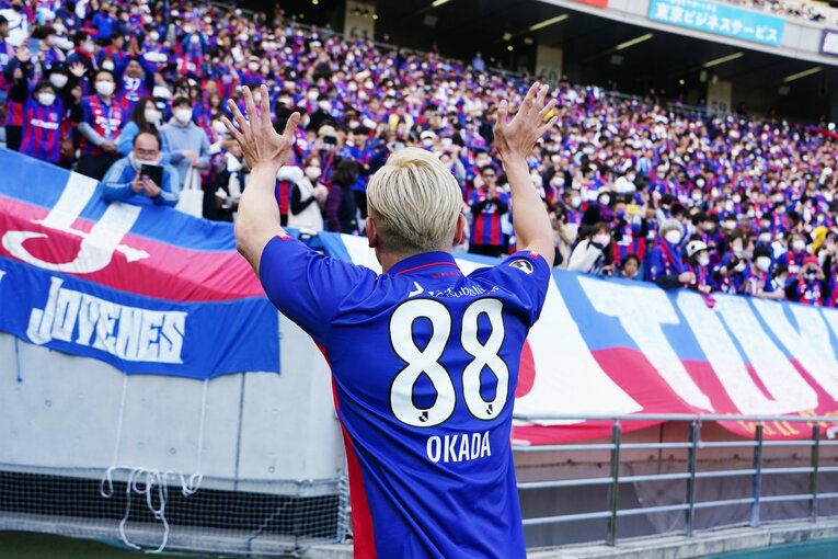 サポーターにてを振るオカダ・カズチカ