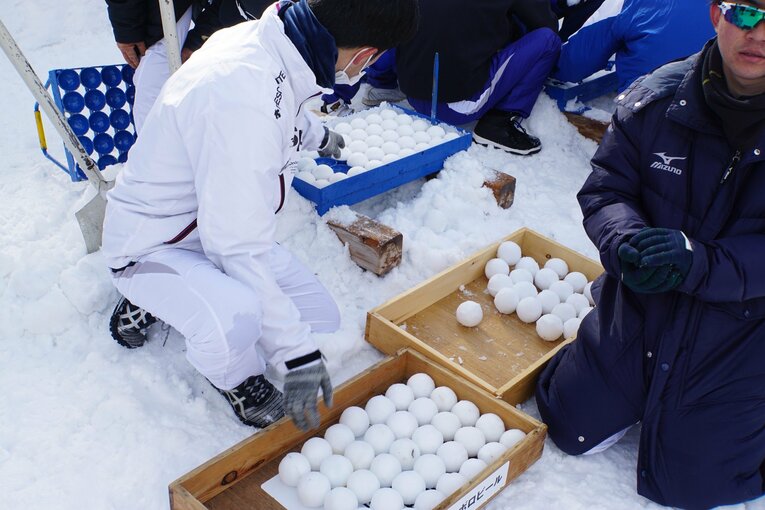 専用の製造機によってつくられる雪球。雪球が割れないよう製造機で圧雪した上に、両手で固める