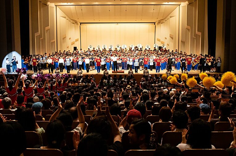 舞台一杯に広がった吹奏楽、応援団などの出演者たち。観客と一体化した盛り上がりは、尋常ではない興奮を呼ぶ。 ／ photograph by KYODO TOKYO