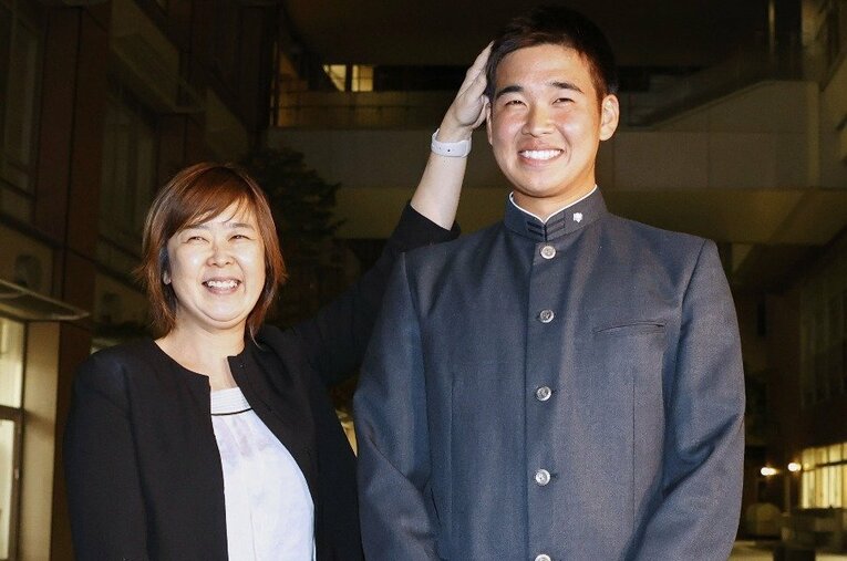 オリックスから1位指名を受け、母美智代さん（左）と笑顔を見せる福岡大大濠高の山下舜平大投手 ／ photograph by KYODO