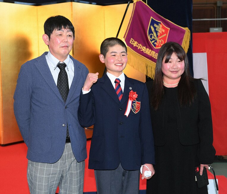 元騎手で調教師の父・輝彦さん（左）と元騎手の母・広美さん。競馬学校の卒業式で親子3人が揃った　©NIKKAN SPORTS