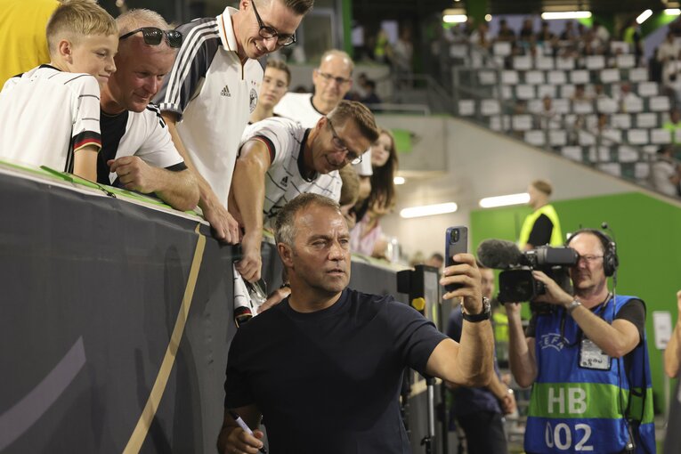 試合前にはファンからの求めに応じて自撮り（セルフィー）をする余裕もあったフリック監督だったが…　©DPA/JIJI PRESS