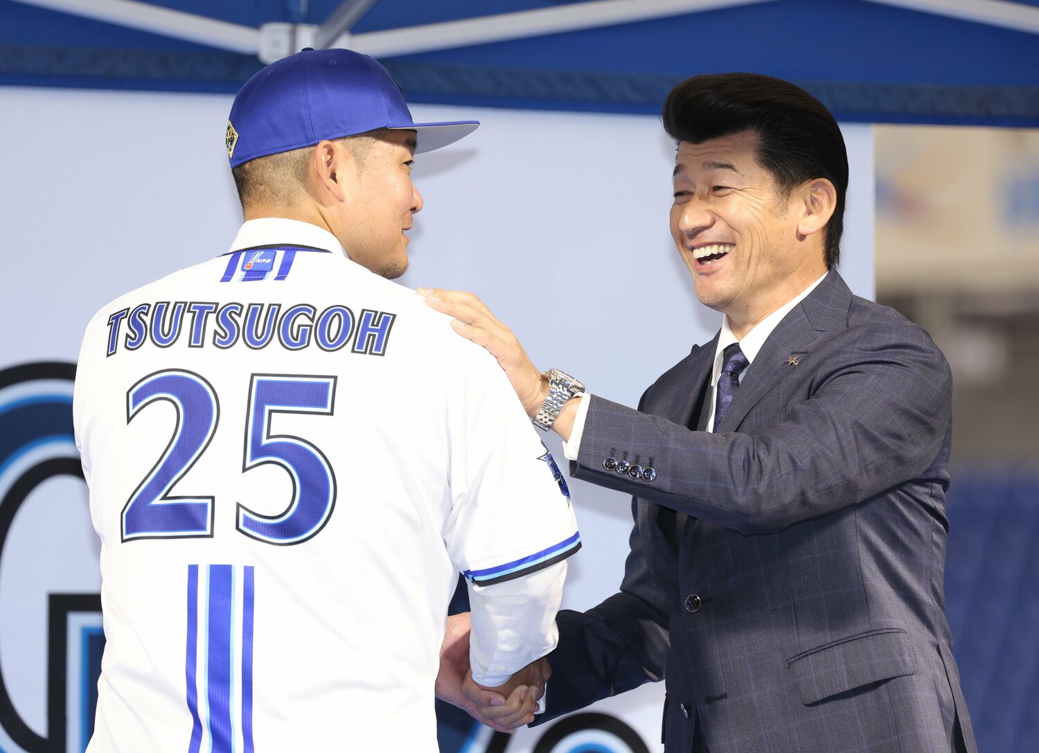 三浦大輔監督から、筒香不在時も「空き番号」となっていた背番号25のユニフォームを着せられる筒香　©JIJI PRESS