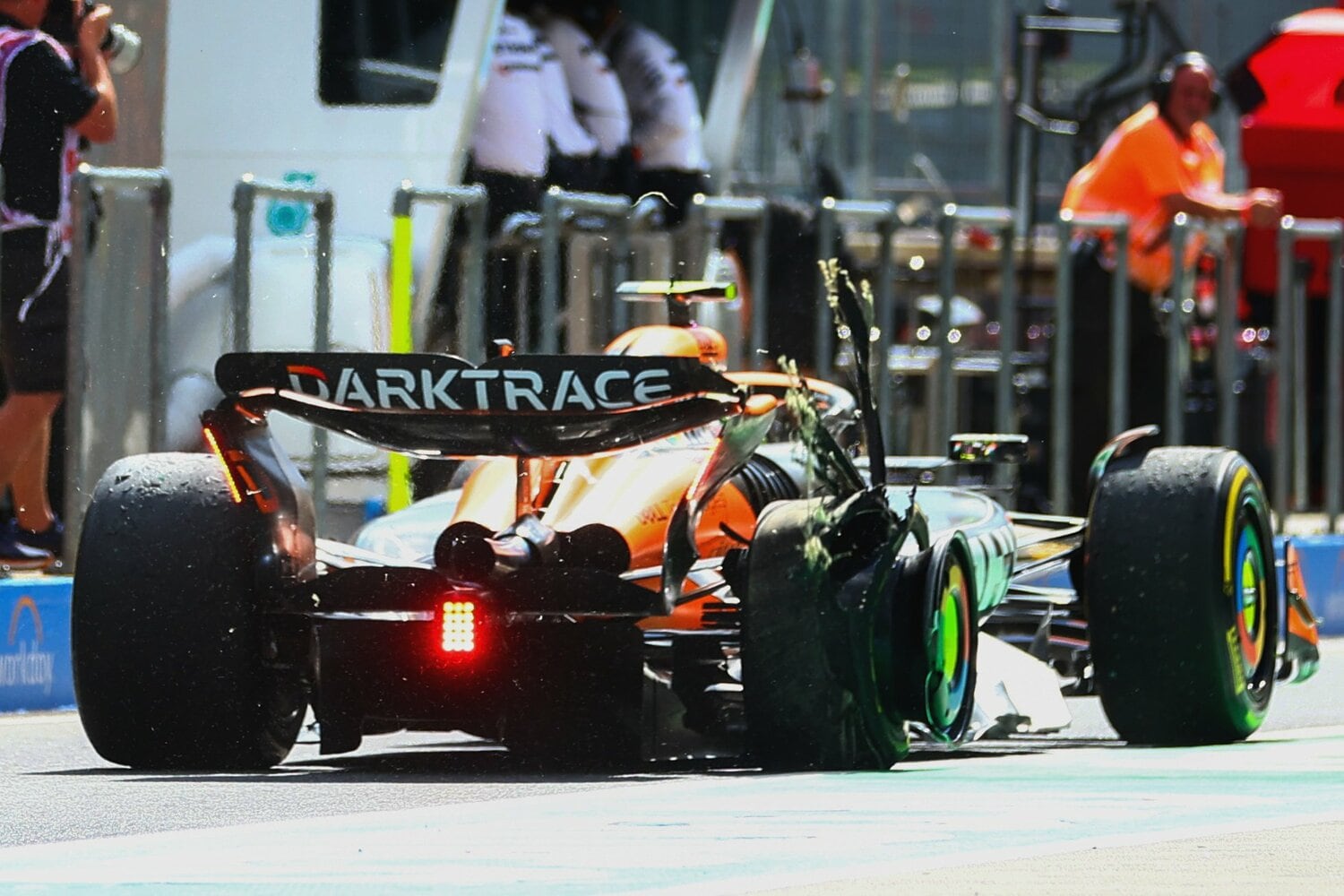 右リアタイヤがバーストした状態でピットロードを走るノリス　©Getty Images