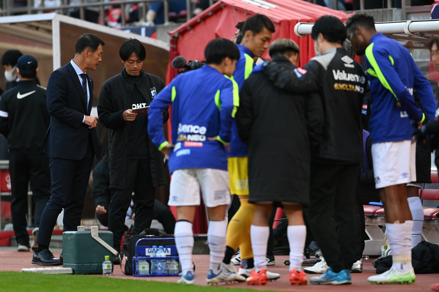 ベンチ前でタブレットを囲み、他会場の試合をチェックする様子