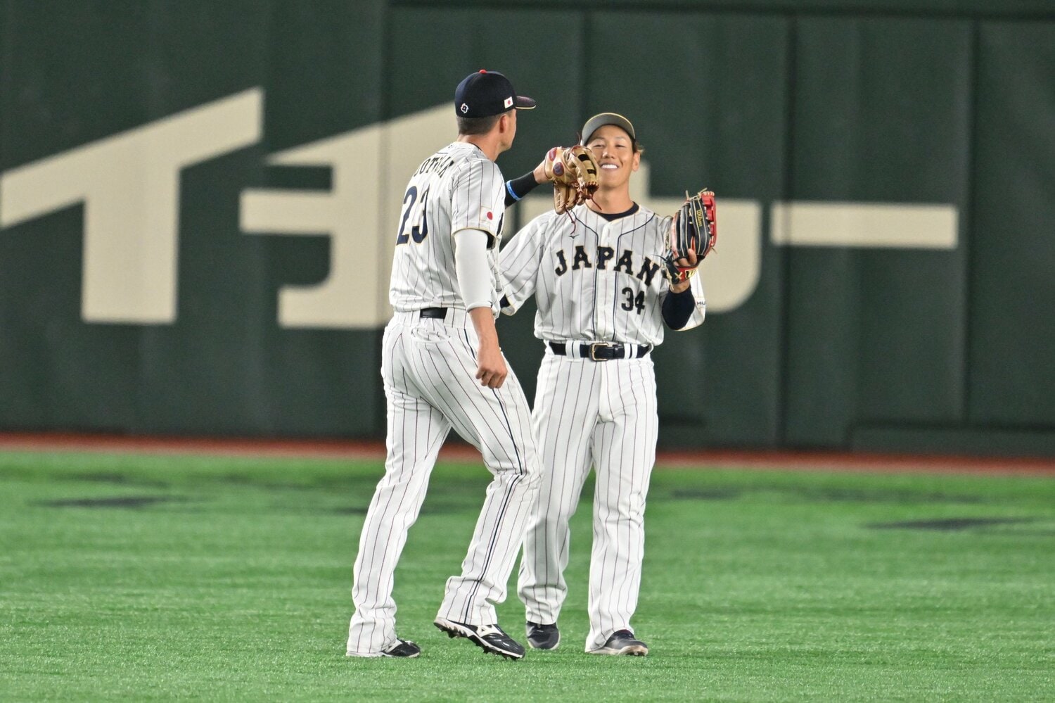 ヌートバー（左）と吉田、外野でじゃれ合う殊勲の2選手　©Naoya Sanuki