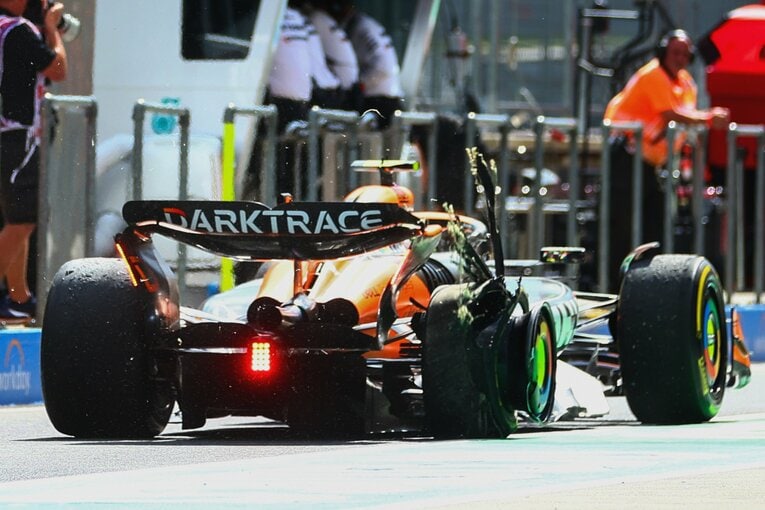 右リアタイヤがバーストした状態でピットロードを走るノリス　©Getty Images