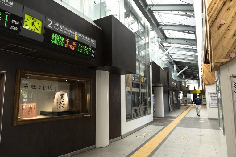 東京五輪に向けてリニューアルされた構内、将棋の駒が飾られたコーナー。「千駄ケ谷駅」の文字は羽生善治九段によるもので、「王将」は大山康晴十五世名人によるものだという