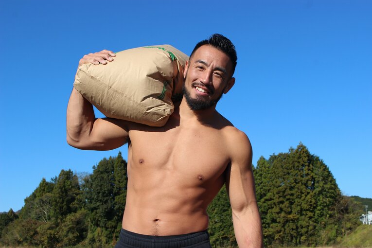 自慢の米を担いでポーズ決める手塚裕之（1枚目／全4枚）©Number Web